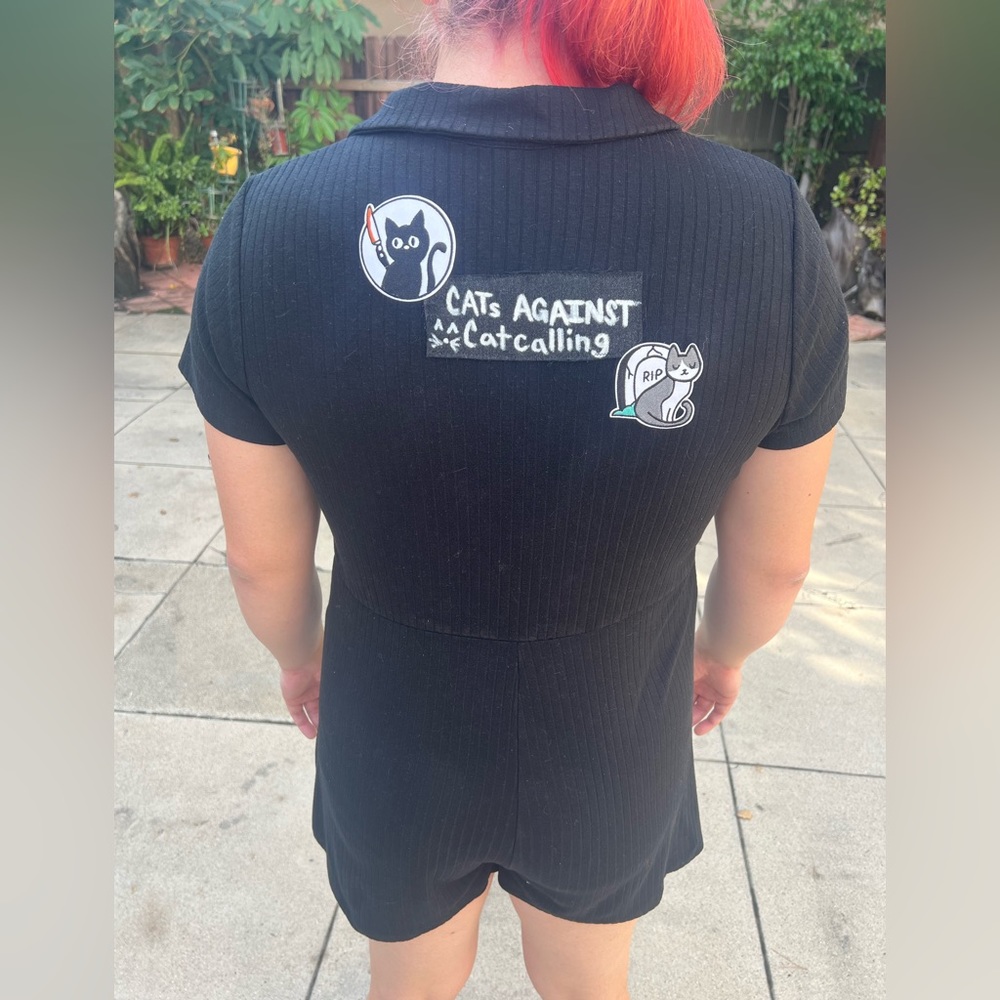 Black short sleeve and pant onesie romper with a button up front.